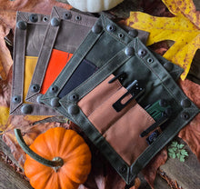 Set of leather tool rolls with tools on a wooden surface with autumn leaves and pumpkins.