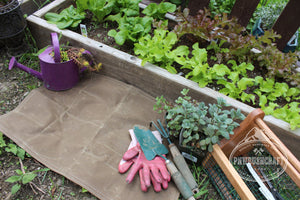 tan waxed canvas groundcloth laying on ground by garden by PNWBUSHCRAFT