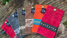 Set of colorful fabric pouches with patterns on a wooden surface