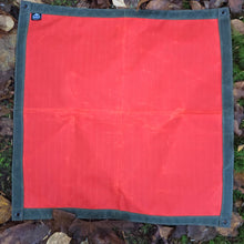 orange fabric square on a bed of leaves