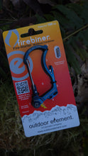Blue carabiner on a 'Firebiner' card with 'Outdoor Element' branding, on a natural background.