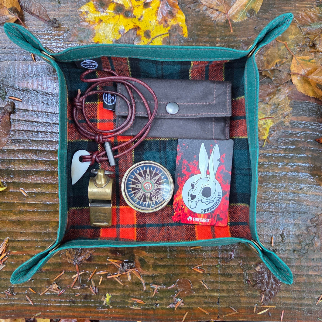 Multicolored pouch with nature-themed items on a wooden surface surrounded by autumn leaves.