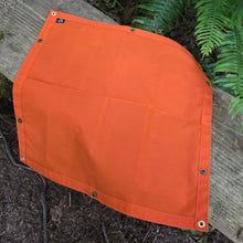 Orange tarp on a wooden surface with green foliage in the background
