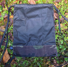 Black bag on a grassy ground with leaves